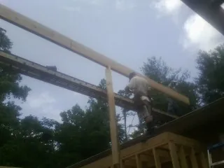 Carpenter setting a ridge beam over a new addition frame — Ice Dam Removal by Roofing Brothers in Lucerne Valley