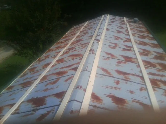 Rusted metal roof panels with new wood purlins before replacement — Storm Damage Roof Repair in Lucerne Valley by Roofing Brothers