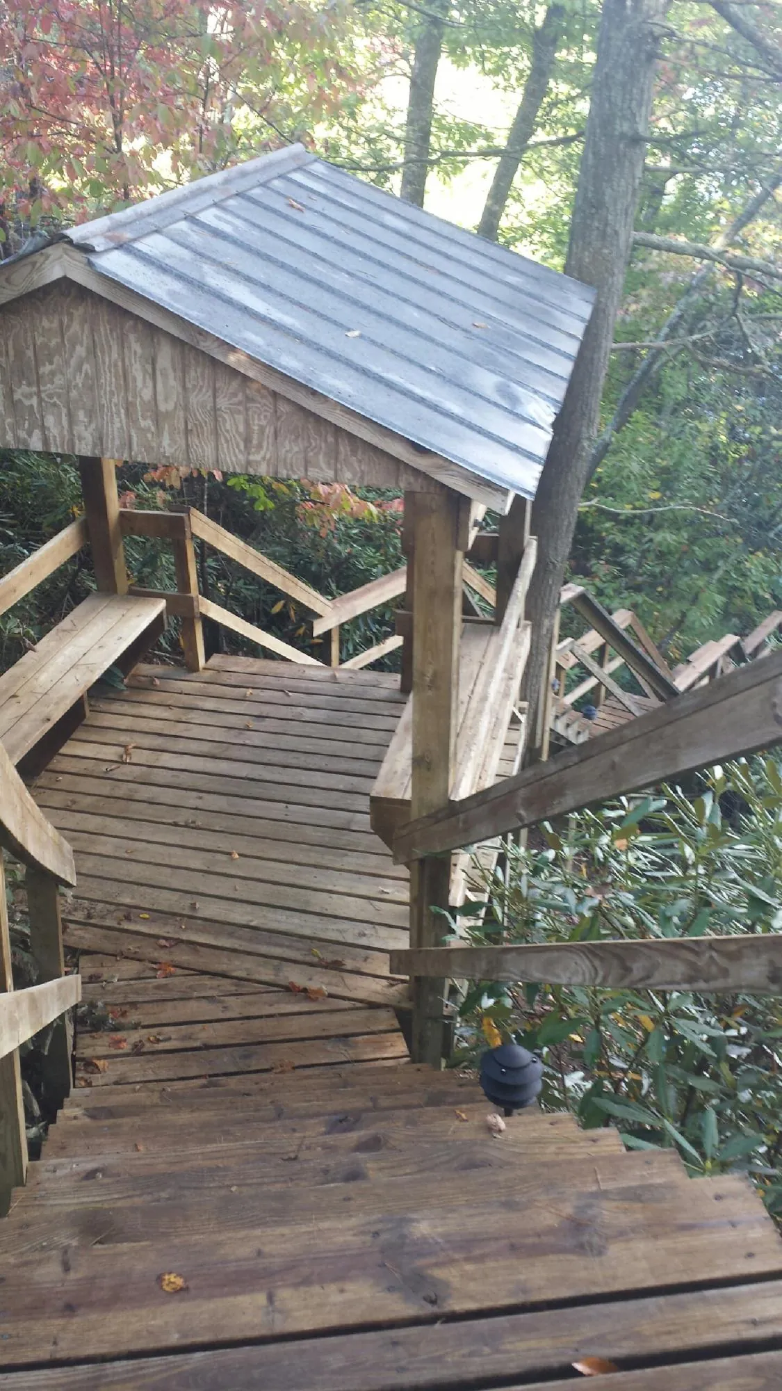 Metal roofed shelter over wooden steps on a wooded walkway — Skylight Repair & Installation work by our crew in Lucerne Valley